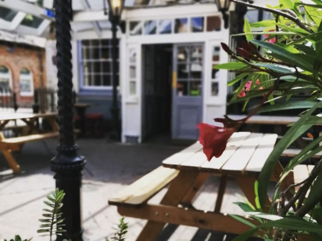 Covered pub patio with outdoor seating and flowers